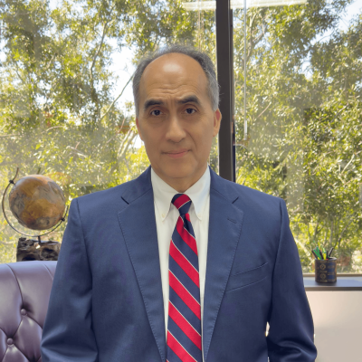 Houston Personal Injury Attorney Rick Molina in a professional building office with a window view of the top of the trees outside the higher floor office building.